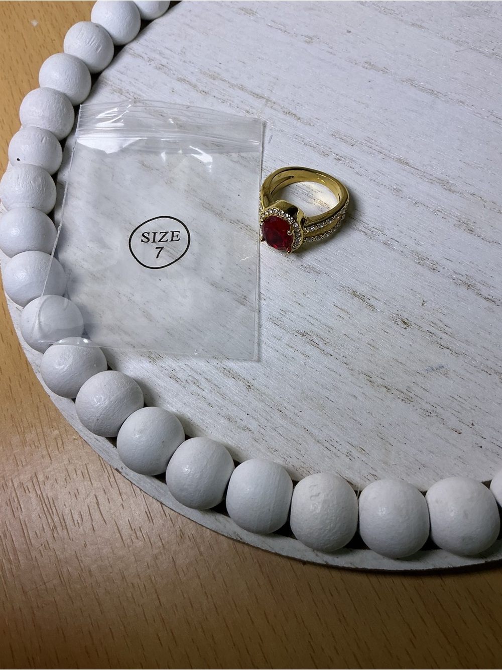 Gold Ring with Red Gemstone and Halo Accent